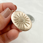 Load image into Gallery viewer, A collection of oval star pendants in silver, black rhodium, gold, and rose gold colors, displayed on a textured background.