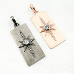 Load image into Gallery viewer, Two sterling silver rectangle star pendants with gemstones. One pendant is black rhodium plated with a clear gemstone, and the other is rose gold plated with a blue gemstone.