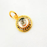 Load image into Gallery viewer, A round sterling silver charm with a gold plated border and a central polki diamond surrounded by black rhodium, on a white fabric background.