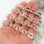 Load image into Gallery viewer, A person's hand holding a sterling silver hollow flat oval link chain.