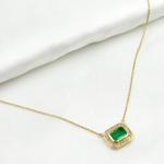 Load image into Gallery viewer, A 14k solid gold rectangle necklace with a green emerald and diamonds, displayed against a white background.