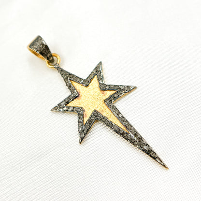 A set of three star-shaped diamond pendants in different finishes: one with black rhodium, one gold-plated, and one rose gold-plated, displayed against a white background.