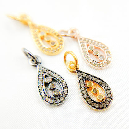 A collection of sterling silver drop charms with varying two-tone finishes and embedded with diamond stones.