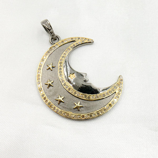 A two-tone (black rhodium and gold plated) silver pendant in the shape of a crescent moon with stars, featuring diamond accents.