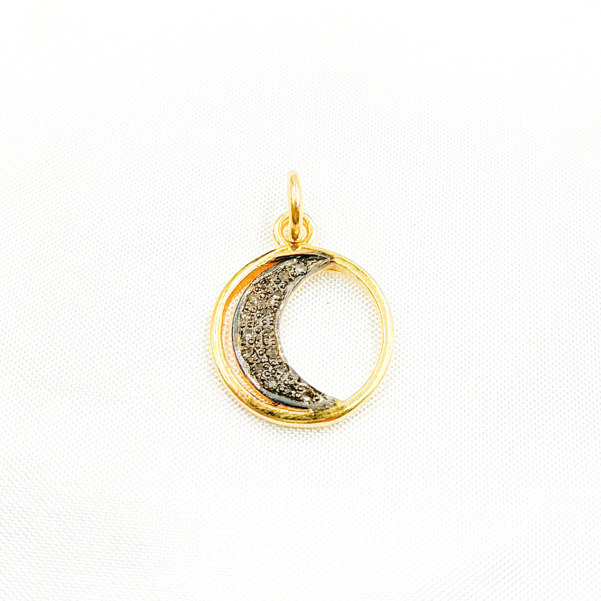 A selection of round moon charms in different finishes: silver with black rhodium, gold plated, and rose gold plated, each featuring a patterned interior.