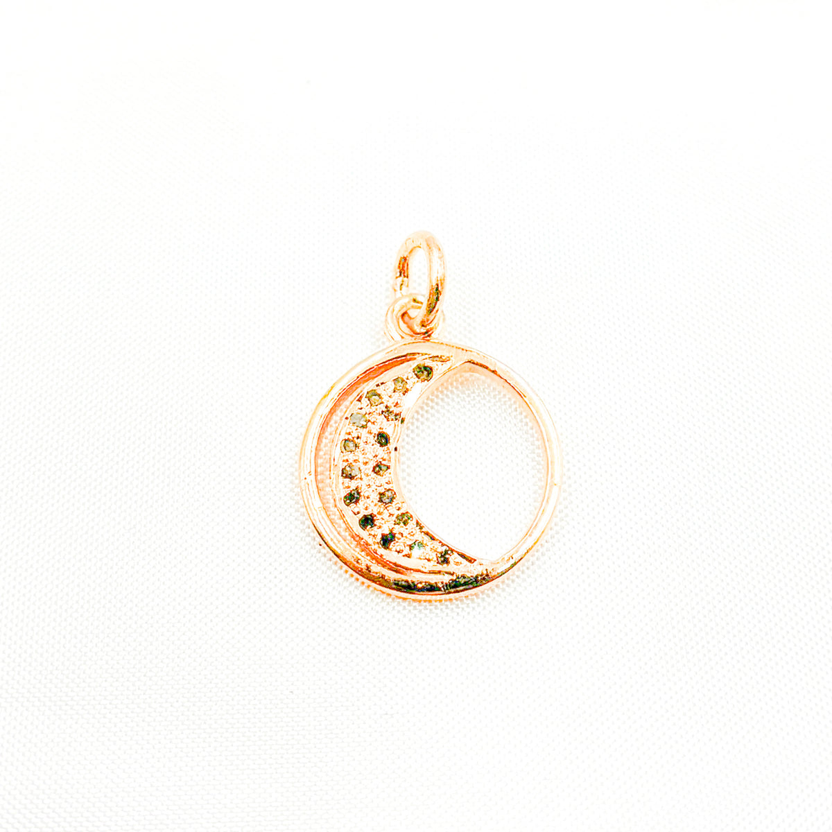 A selection of round moon charms in different finishes: silver with black rhodium, gold plated, and rose gold plated, each featuring a patterned interior.