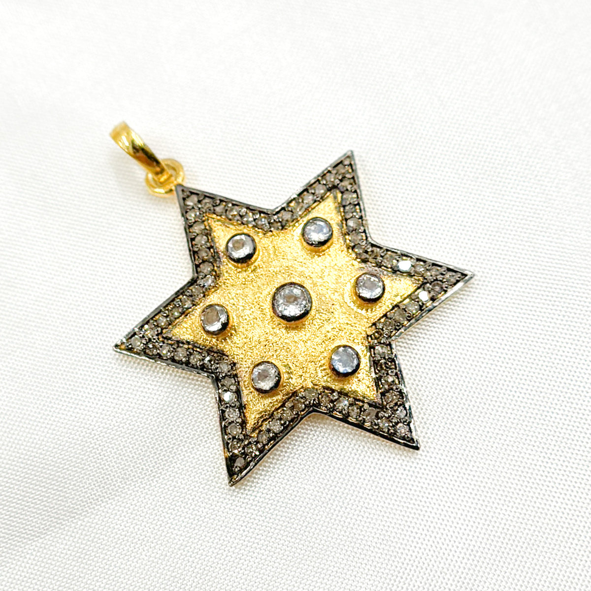 A collection of star-shaped pendants with varying metallic finishes and embellishments, including diamonds and gemstones.